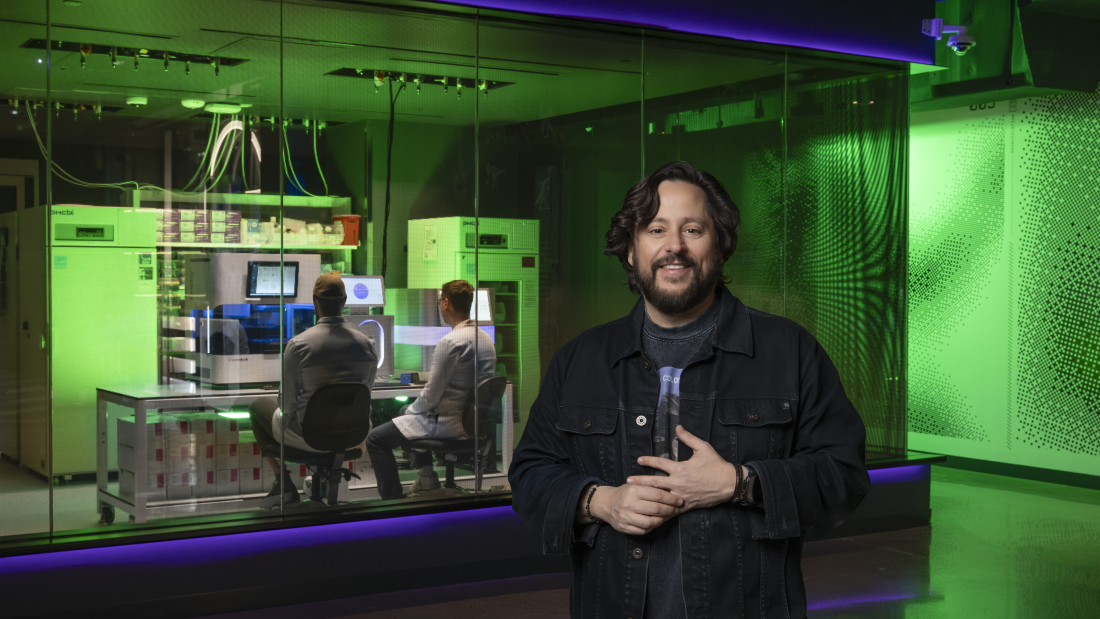 ben lamm standing in front of a lab, two scientists wearing white coats in background ben lamm standing in front of a lab, two scientists wearing white coats in background